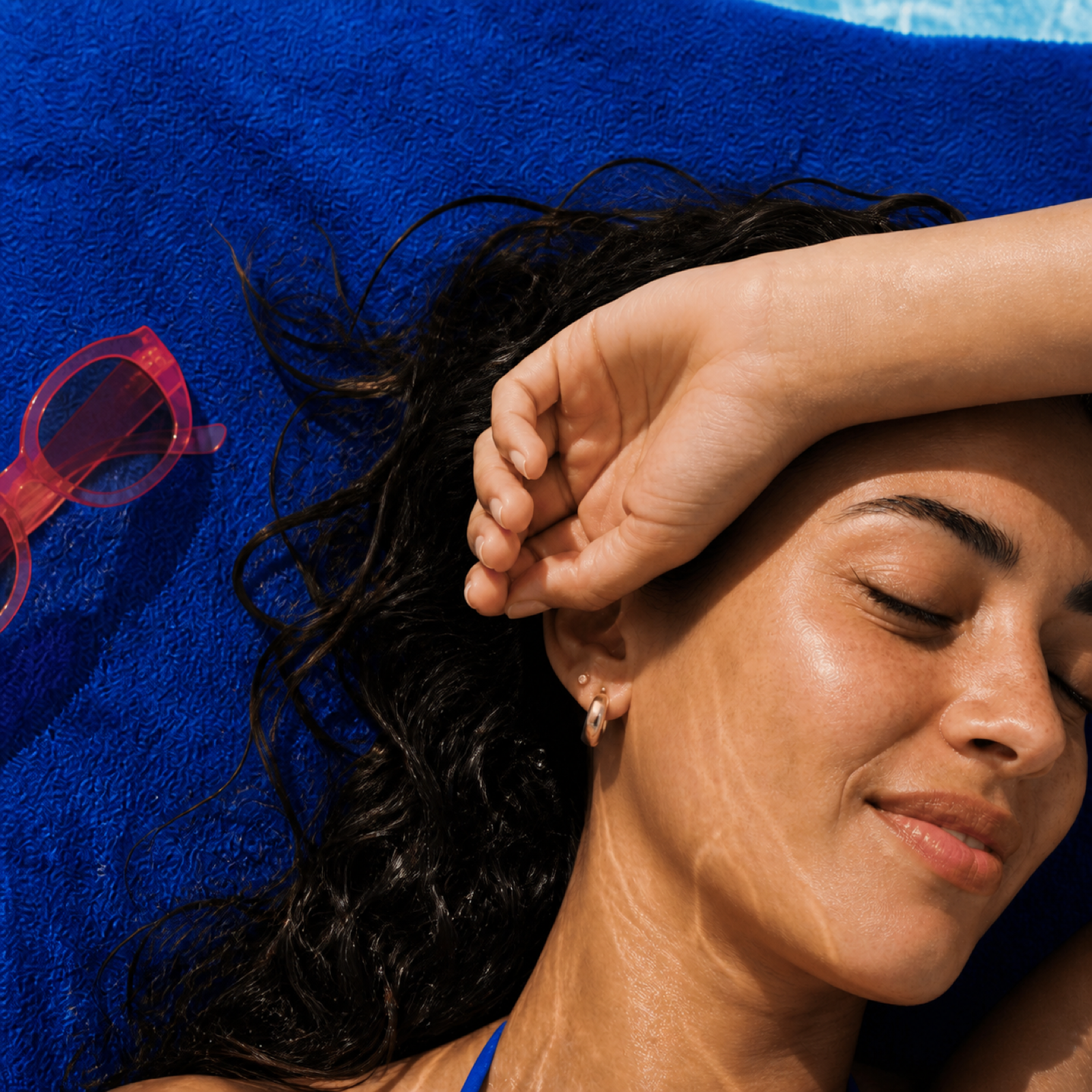 Egyptian woman relaxing poolside in bright sunlight